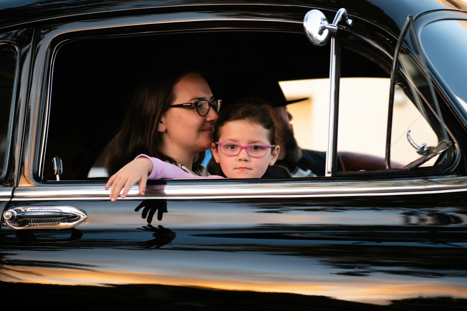 Família feliz em viagem ao lado do carro, ao pôr do sol